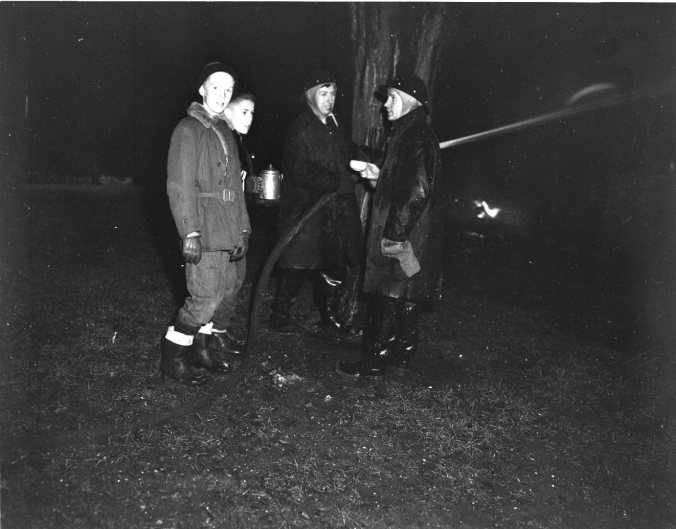 Bill Swann and L.D. Bowman offer coffee to firemen Doug Martin and Harold Hamilton